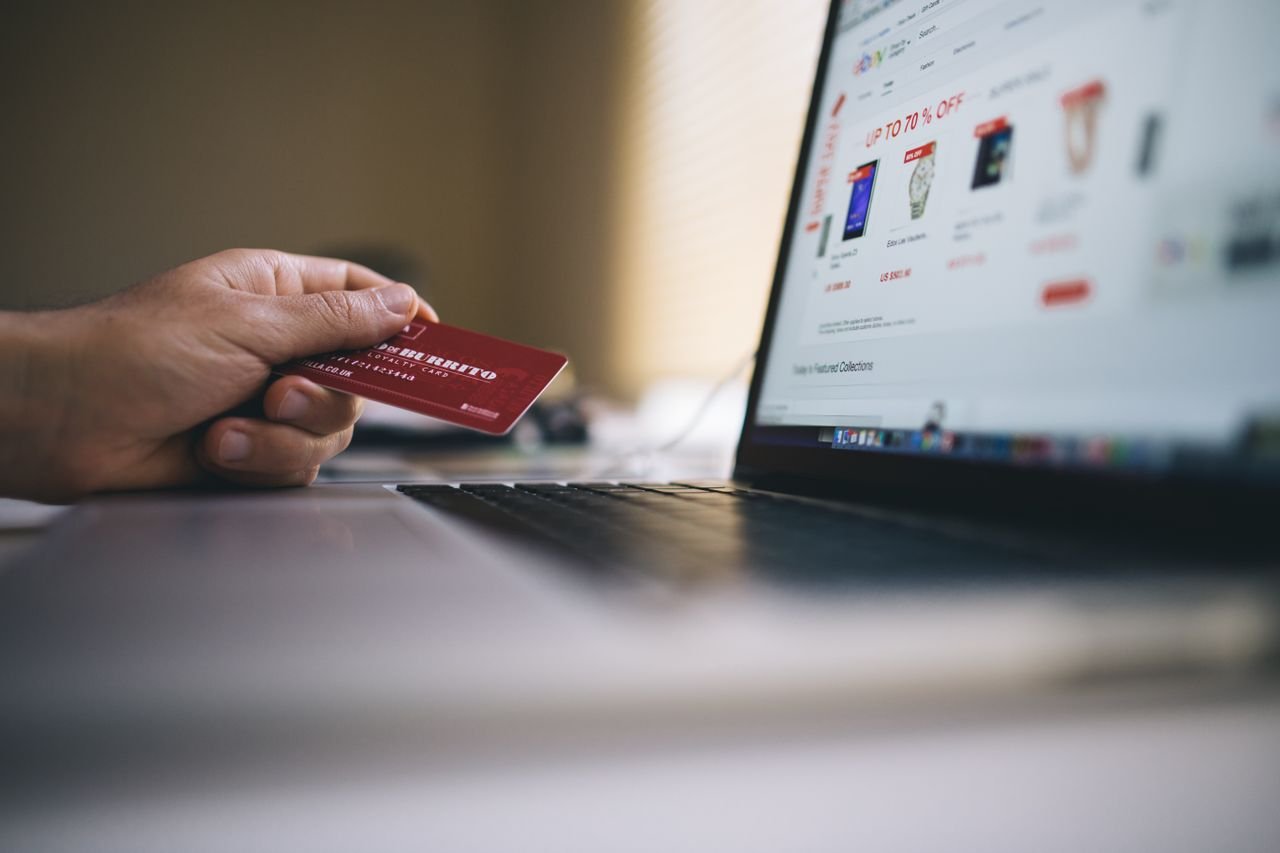 The Art of Drawing Readers In: Your attractive post title goes here Person holding a credit card while shopping online on a laptop, indicating ecommerce transactions.