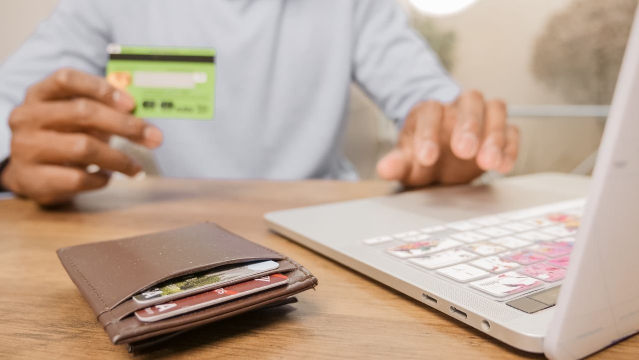 Mastering the First Impression: Your intriguing post title goes here Close-up of hands with a bank card and laptop for online shopping. Perfect for illustrating e-commerce concepts.